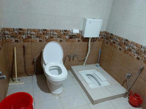 a bathroom with a toilet in a tiled room at SEE MOTEL in Muzaffarabad