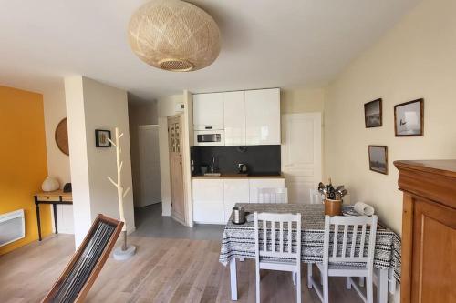 une cuisine et une salle à manger avec une table et des chaises dans l'établissement Le Repère des Surfeurs, à Wissant