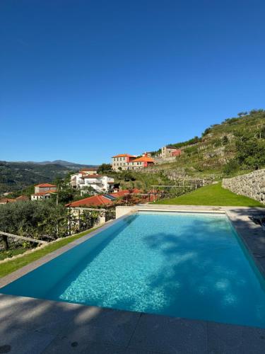 a swimming pool with a view of a villa at Casas do Monte in Resende