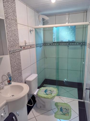 uma casa de banho com um chuveiro, um WC e um lavatório. em POUSADA ALTERNATIVA MANU LAGES em Lages