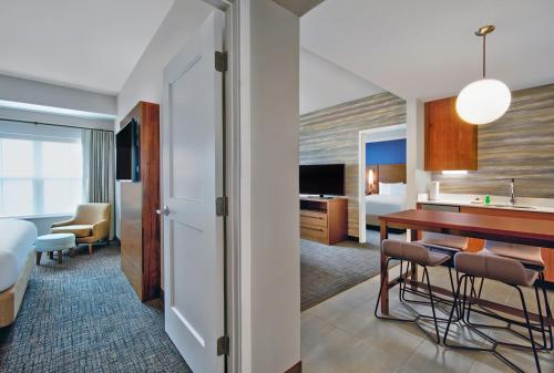 ein Hotelzimmer mit einer Küche und einem Esszimmer in der Unterkunft Residence Inn by Marriott Orlando at FLAMINGO CROSSINGS Town Center in Orlando