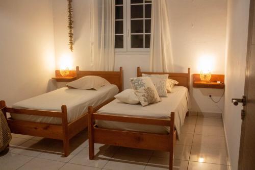 a bedroom with two beds and two lights on the wall at Ô'Bèl Ter in Pointe-Noire