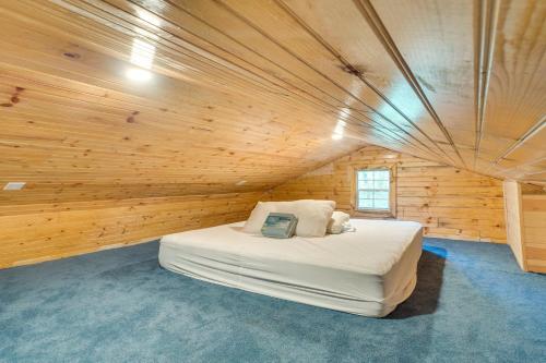 een slaapkamer met een bed in een houten kamer bij Cozy Hemphill Cabin with Lake Views and Deck! in Hemphill