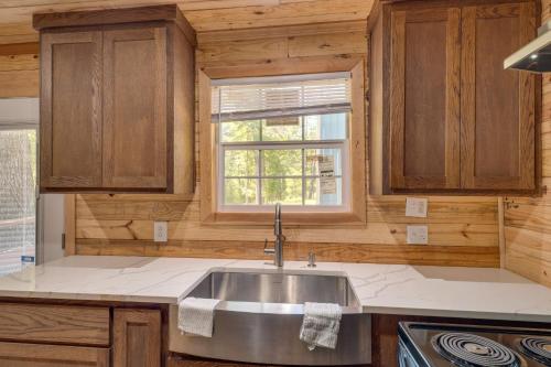 a kitchen with a sink and a window at Quiet Hemphill Cabin Retreat Near Toledo Bend Lake in Hemphill