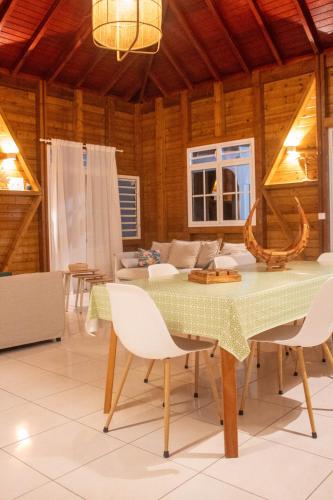 a dining room with a green table and chairs at Ô'Bèl Ter in Pointe-Noire