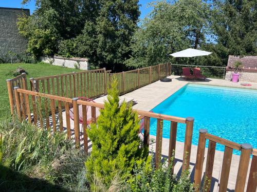- une piscine avec une clôture en bois à côté dans l'établissement Au chat qui bulle - Villa avec piscine chauffée - 1h10 de Paris, à Villemaréchal