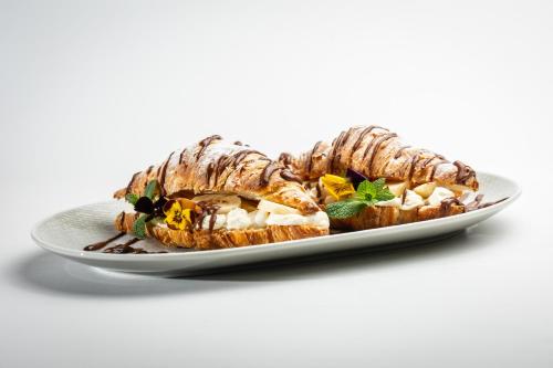 a plate of food with a croissant sandwich at Basch House 1887 Rooms, Subotica in Subotica