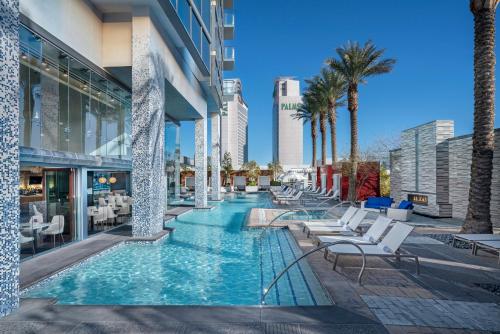 uma piscina com cadeiras e palmeiras num edifício em StripViewSuites at Palms Place em Las Vegas