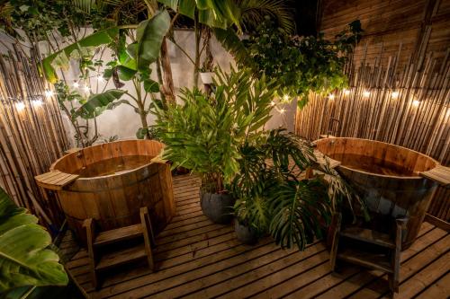 2 baignoires en bois avec des plantes sur une terrasse en bois dans l'établissement Terasu Hotel Boutique Salento, à Salento