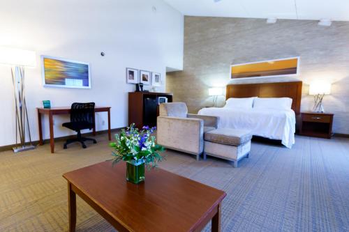 una habitación de hotel con una cama y una mesa con flores en Holiday Inn Cape Cod-Falmouth, an IHG Hotel, en Falmouth