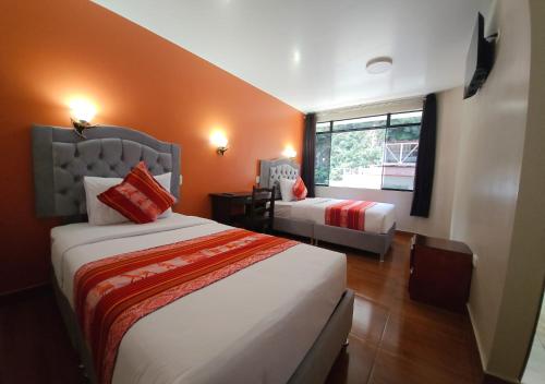 una camera d'albergo con due letti e una finestra di Hotel Horizonte a Machu Picchu