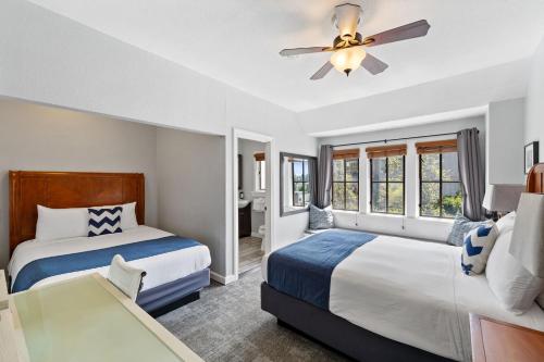 a bedroom with two beds and a ceiling fan at College Inn Hotel in Seattle