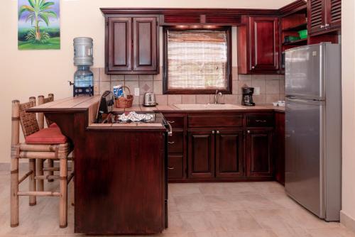 a kitchen with wooden cabinets and a stainless steel refrigerator at X'tan Ha- The Waterfront in San Pedro