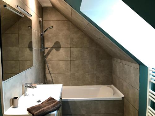 La salle de bains est pourvue d'une baignoire et d'un lavabo. dans l'établissement Villa Fétuque Crin d'Ours à Merlimont, à Merlimont