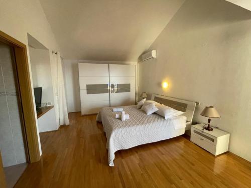 a bedroom with a white bed and a wooden floor at Apartment Lucille in Kali