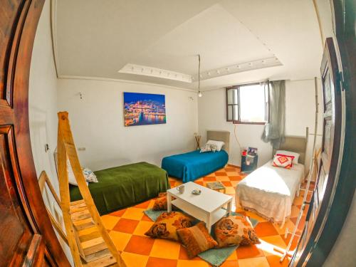 a small room with a bed and a table at Buena vista morroco GUEST HOUSE in Tamraght Ouzdar