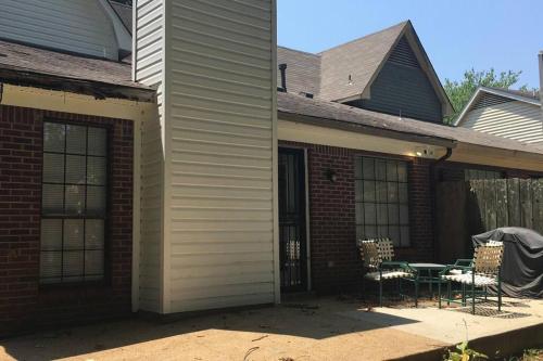a house with a patio with chairs and a table at Cozy Bartlett home with garage, fenced backyard in Memphis