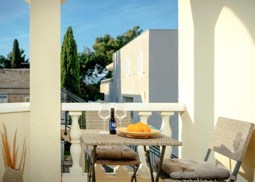 a table with a plate of oranges on a balcony at Villa Rajski Dvor in Bol