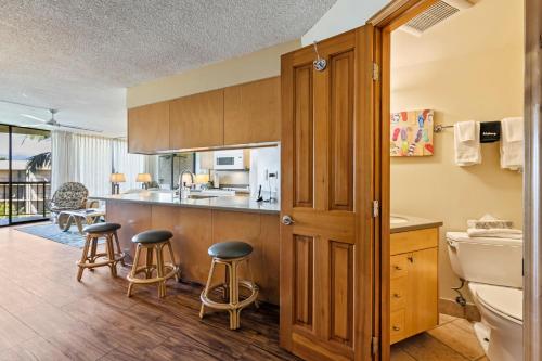 eine Küche mit einer Theke und Hockern in einem Zimmer in der Unterkunft Maui Sunset in Kihei