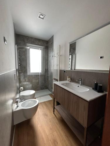 un bagno con lavandino, vasca e WC di La Finestra Blu Alba 1 ad Alba