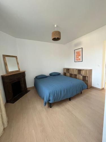 a bedroom with a blue bed and a fireplace at Charmante maison de ville in Bourges