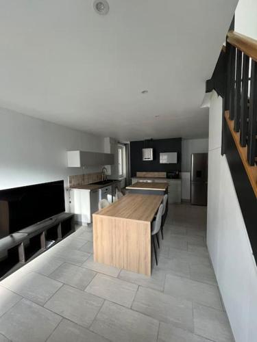 une grande cuisine avec une table et des bancs en bois dans l'établissement Charmante maison de ville, à Bourges