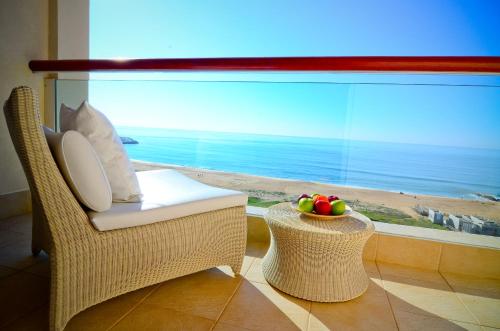 a white couch sitting in front of a window overlooking the ocean at Crowne Plaza Vilamoura - Algarve, an IHG Hotel in Vilamoura