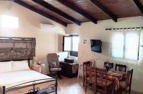 een slaapkamer met een bed en een tafel en een televisie bij Villa Pasas in Koíta