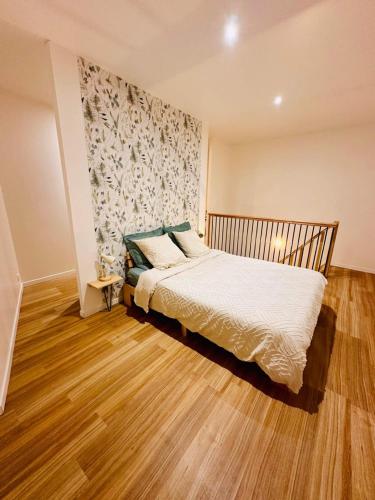 1 dormitorio con 1 cama y suelo de madera en Maison de ville, en Barbezieux