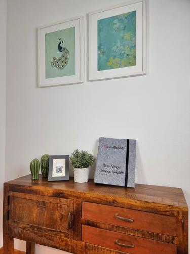 a wooden dresser with two pictures on top of it at Ferienhaus Heckler in Bad Camberg