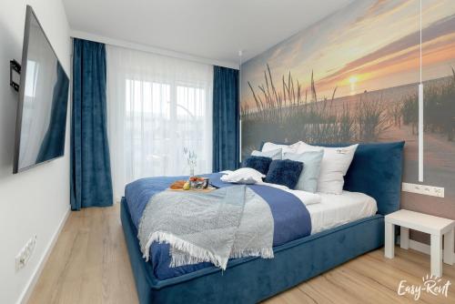 sypialnia z niebieskim łóżkiem i obrazem na ścianie w obiekcie Perfekt SPA w Dziwnowie