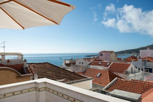 a view of a city with roofs and the ocean at Private Terrace Refúgio in Sesimbra