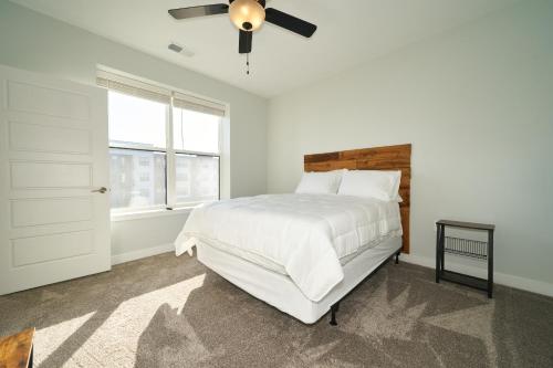 a white bedroom with a bed and a ceiling fan at Rare 1BDR Apt with Pool Gym Parking in Indianapolis