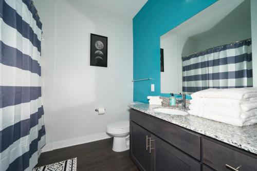 a bathroom with a sink and a toilet and a mirror at Rare 1BDR Apt with Pool Gym Parking in Indianapolis