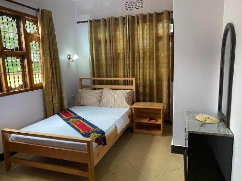 Habitación pequeña con cama y ventana en Maasaifari Moshi 36 en Moshi