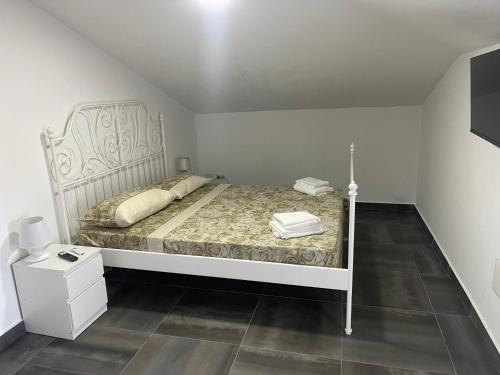 a bedroom with a bed with a white headboard at Villa Lidia & Attico degli artisti, free pets , giardino recintato e attrezzato in Minturno