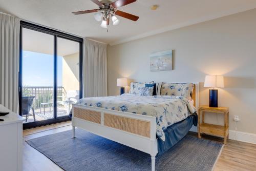 1 dormitorio con 1 cama y ventilador de techo en Oceanfront Resort Condo with Private Beachwalk! en Dauphin Island