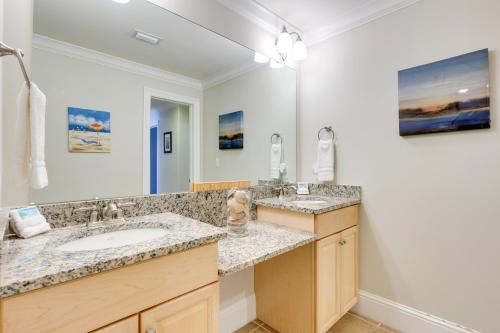 a bathroom with two sinks and a large mirror at Oceanfront Resort Condo with Private Beachwalk! in Dauphin Island