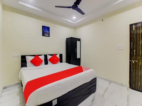 1 dormitorio con 1 cama grande con almohadas rojas en SRI NIRVANA PRIDE en Ibrāhīmpatan