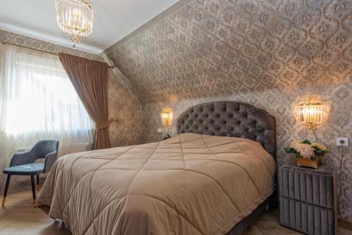 a bedroom with a large bed and a chair at Feel like home Apartment SELF CHECK IN in Klaipėda