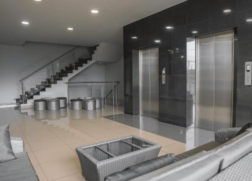 a lobby with a staircase and a couch and chairs at HOTEL NABU VALLEDUPAR in Valledupar