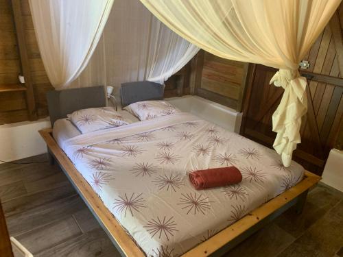 a bed in a room with a canopy at Les îlets caraïbes vue mer in Bouillante