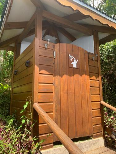a wooden gazebo with a large wooden door at Les îlets caraïbes vue mer in Bouillante