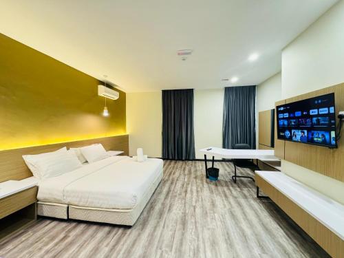 a hotel room with a bed and a flat screen tv at STAR HOTEL in Tawau