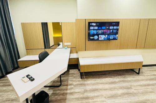 una camera con due scrivanie e una TV a parete di STAR HOTEL a Tawau