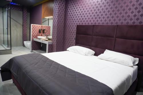 una camera con un grande letto e un bagno di Hotel El Pamas a Mugnano di Napoli