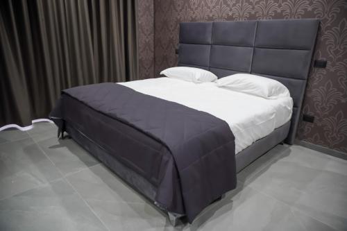 een slaapkamer met een groot bed met een blauw hoofdeinde bij Hotel El Pamas in Mugnano di Napoli