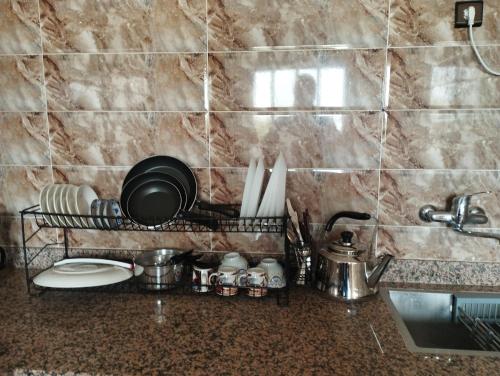 a kitchen counter with a rack of utensils at Appartement Hajar in Oualidia