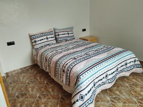 a bed with two pillows on it in a bedroom at Appartement Hajar in Oualidia