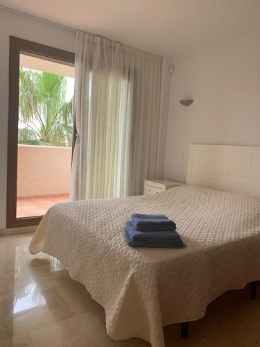 een slaapkamer met een bed met twee blauwe handdoeken erop bij Apartment in Punta Prima (Torrevieja) 200m to Sea in Punta Prima